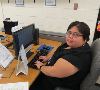A woman at a computer desk.