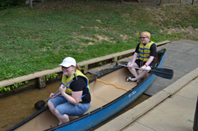 A woman and teenage boy paddling a canoe.